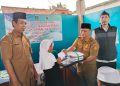 Kepala Desa Ata Sumarta menyalurkan bantuan perlengkapan sekolah secara simbolis. Dok (Nurlan)