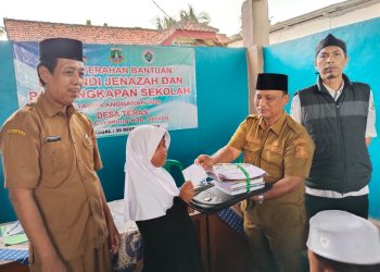 Kepala Desa Ata Sumarta menyalurkan bantuan perlengkapan sekolah secara simbolis. Dok (Nurlan)