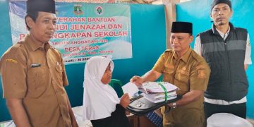 Kepala Desa Ata Sumarta menyalurkan bantuan perlengkapan sekolah secara simbolis. Dok (Nurlan)