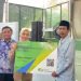 Bupati Serang Ratu Rachmatuzakiyah memberikan simbolis jaminan kesehatan kepada pekerja rentan. Dok. (Nurlan)